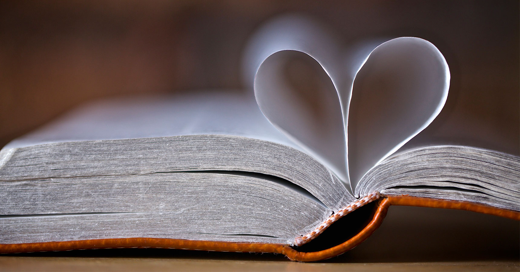 Photo of book, possibly the Bible, with a heart made from two pages.