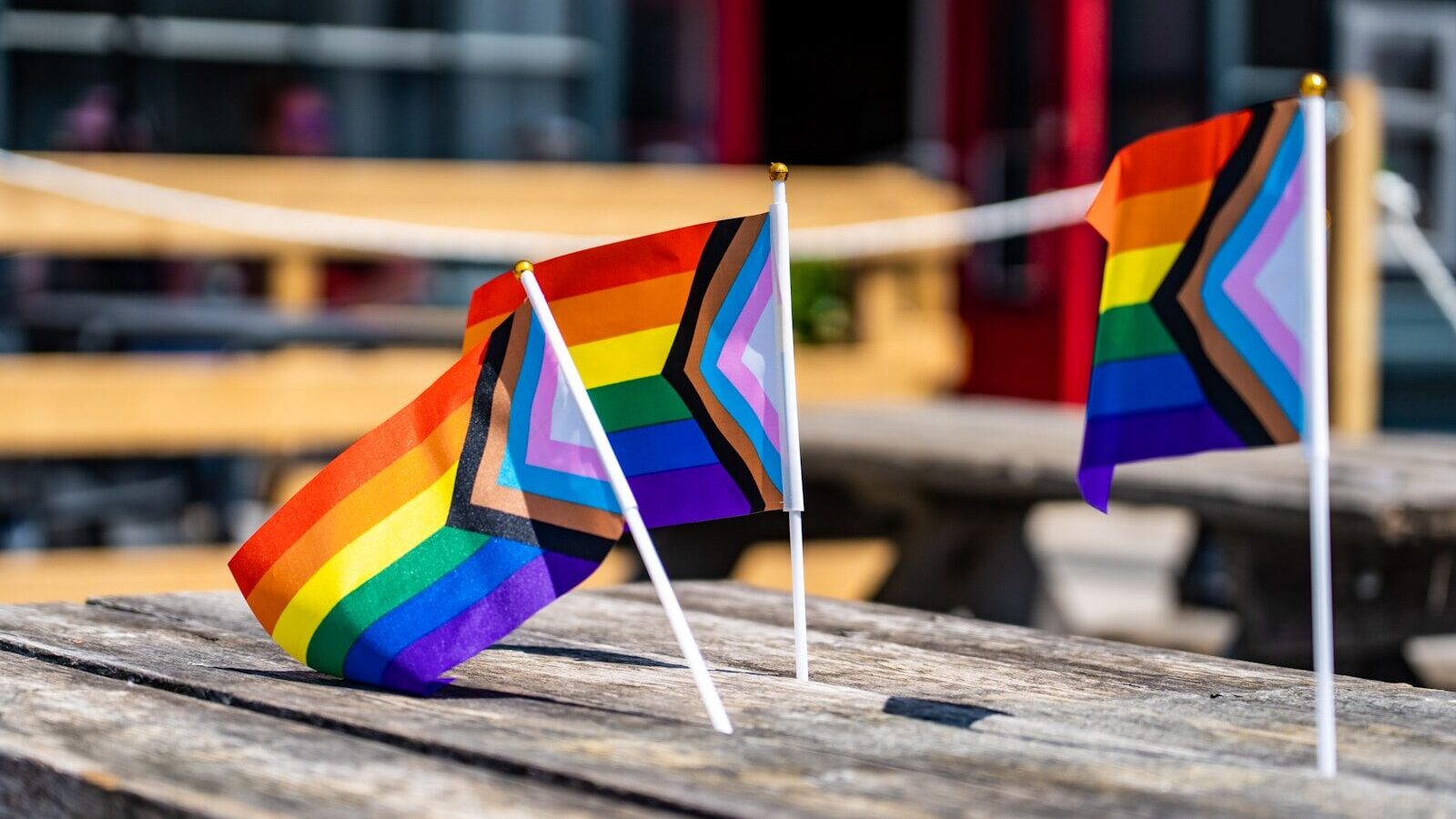 two rainbow flags sitting on top of a wooden table